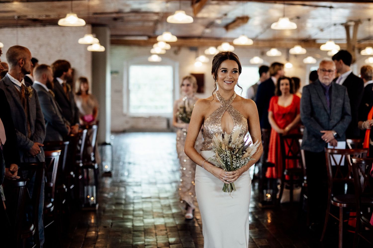 Wedding ceremony in industrial venue with exposed brick walls and pendant lighting.