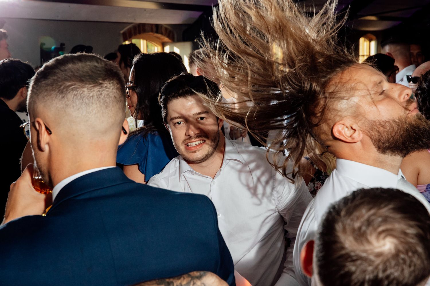 Crowded dance floor with people celebrating at an evening reception event.