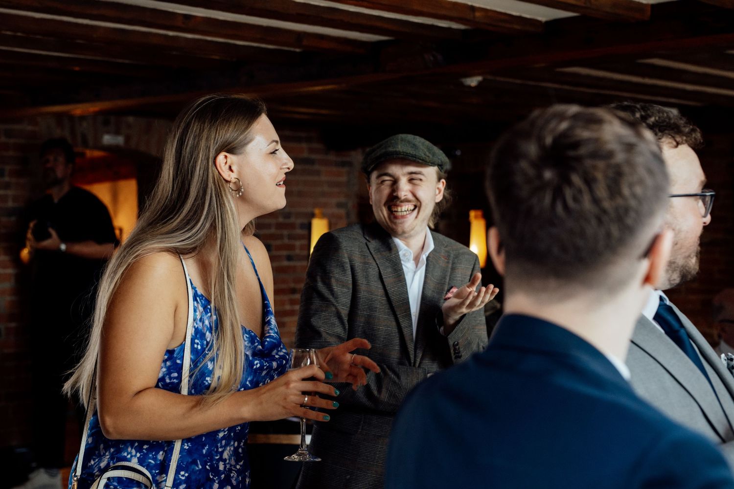 Wedding guests enjoying drinks and conversation during an indoor reception.