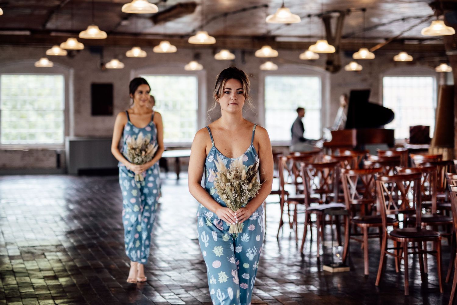Industrial wedding venue interior with exposed brick walls and wooden chairs.