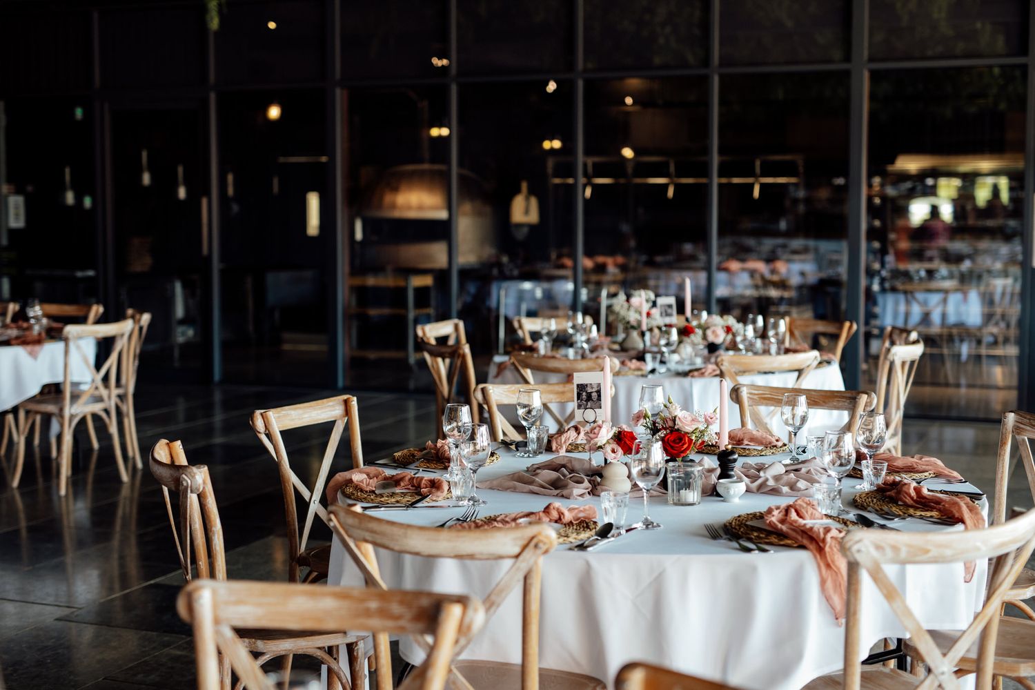 Wedding reception venue with elegant table settings and white linens.