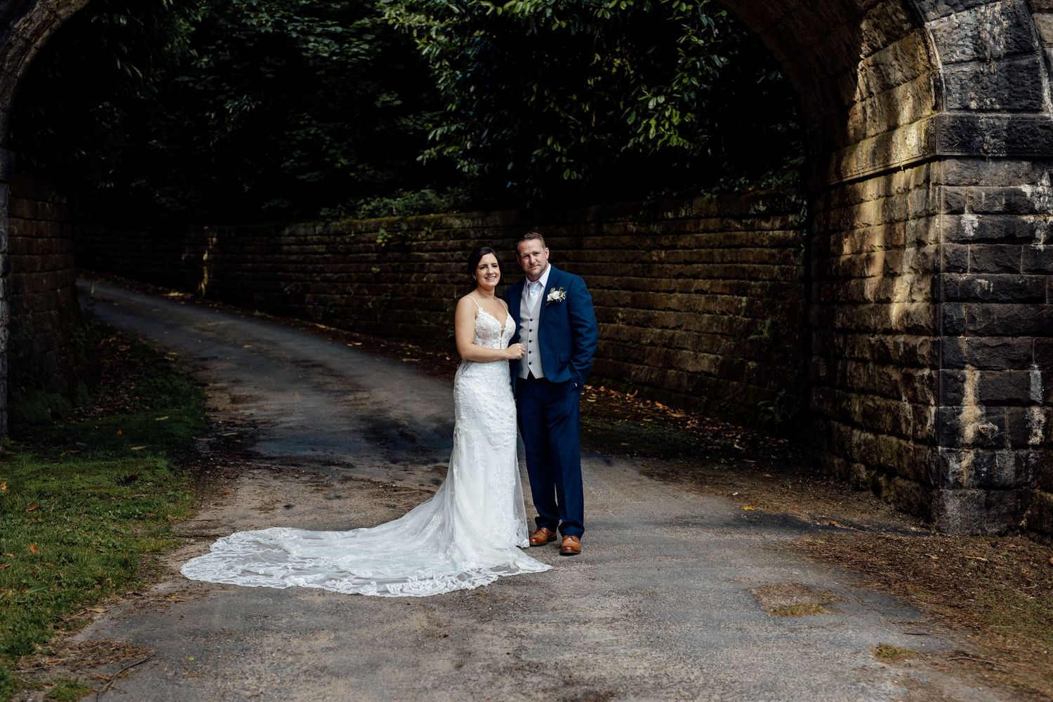 Elegant stone pathway leading through a garden with wedding couple portraits.