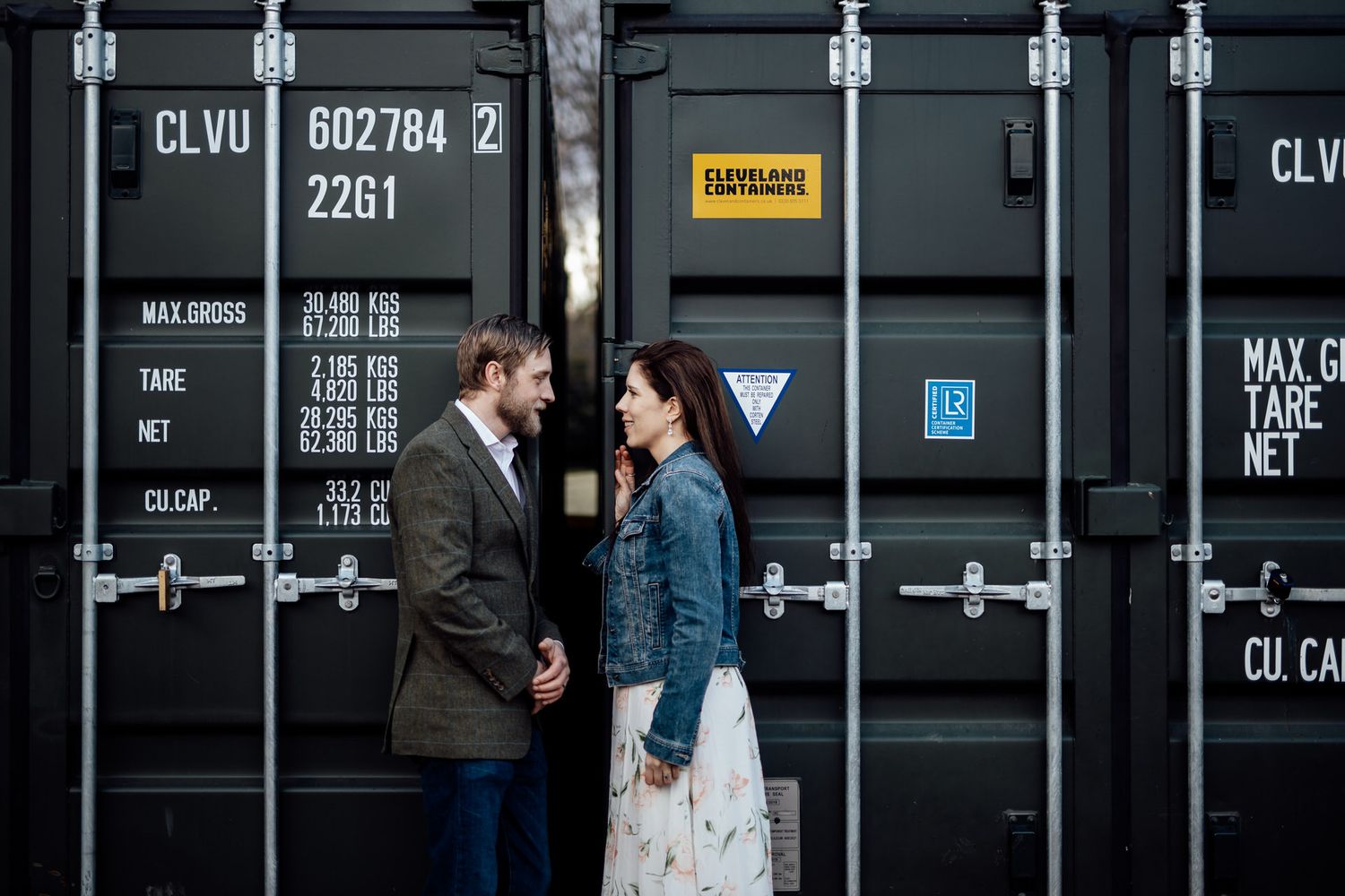 Industrial shipping containers create backdrop for couple's urban photoshoot.