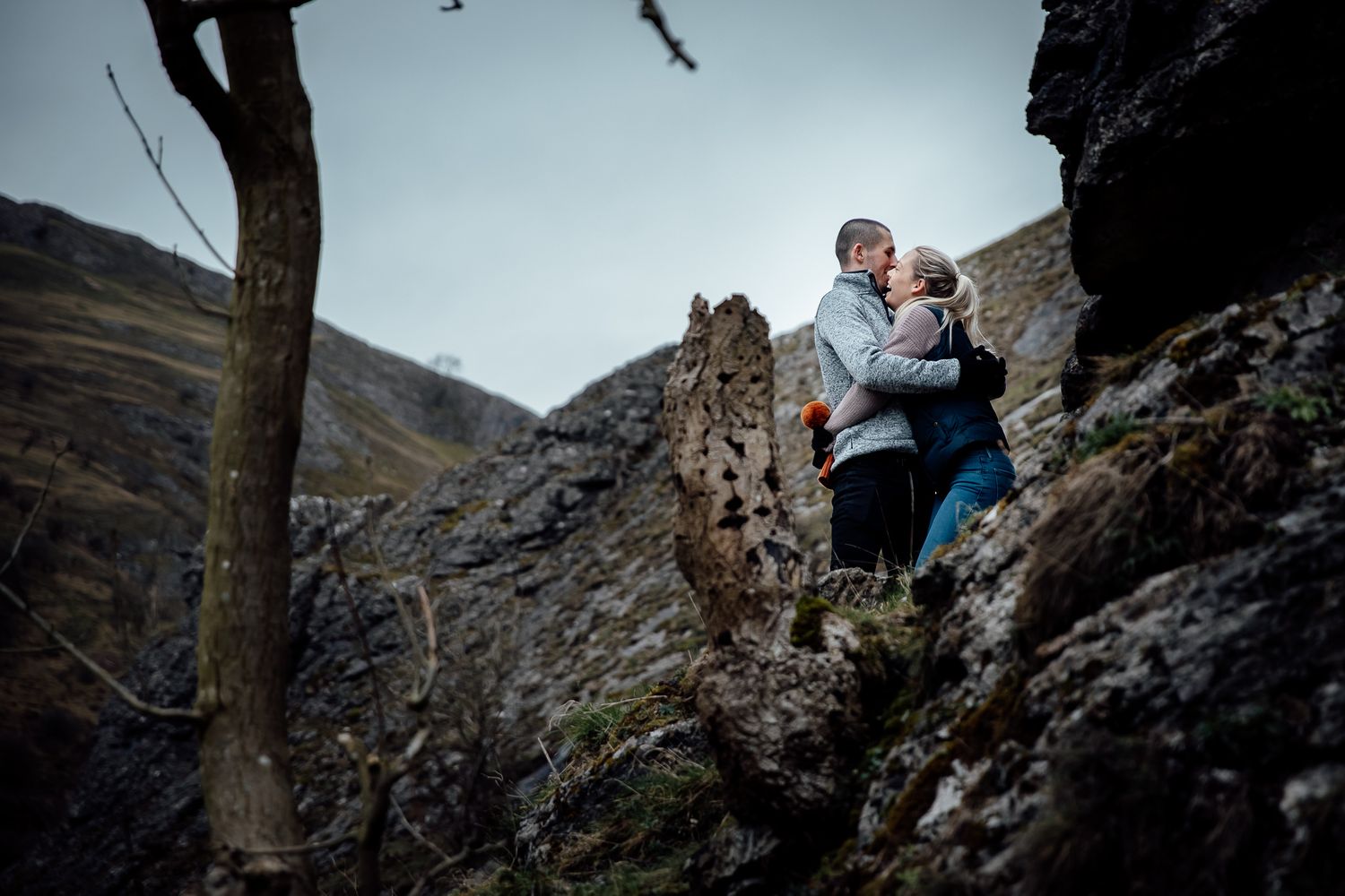 Two people sharing a moment among rocky mountain outcroppings.