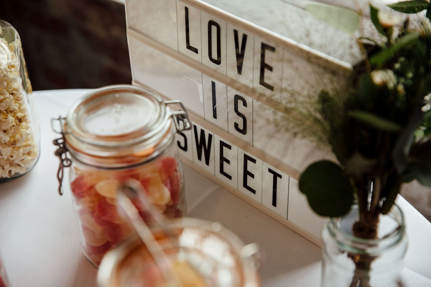Rustic wedding decor with 'LOVE' text sign and mason jar decorations.