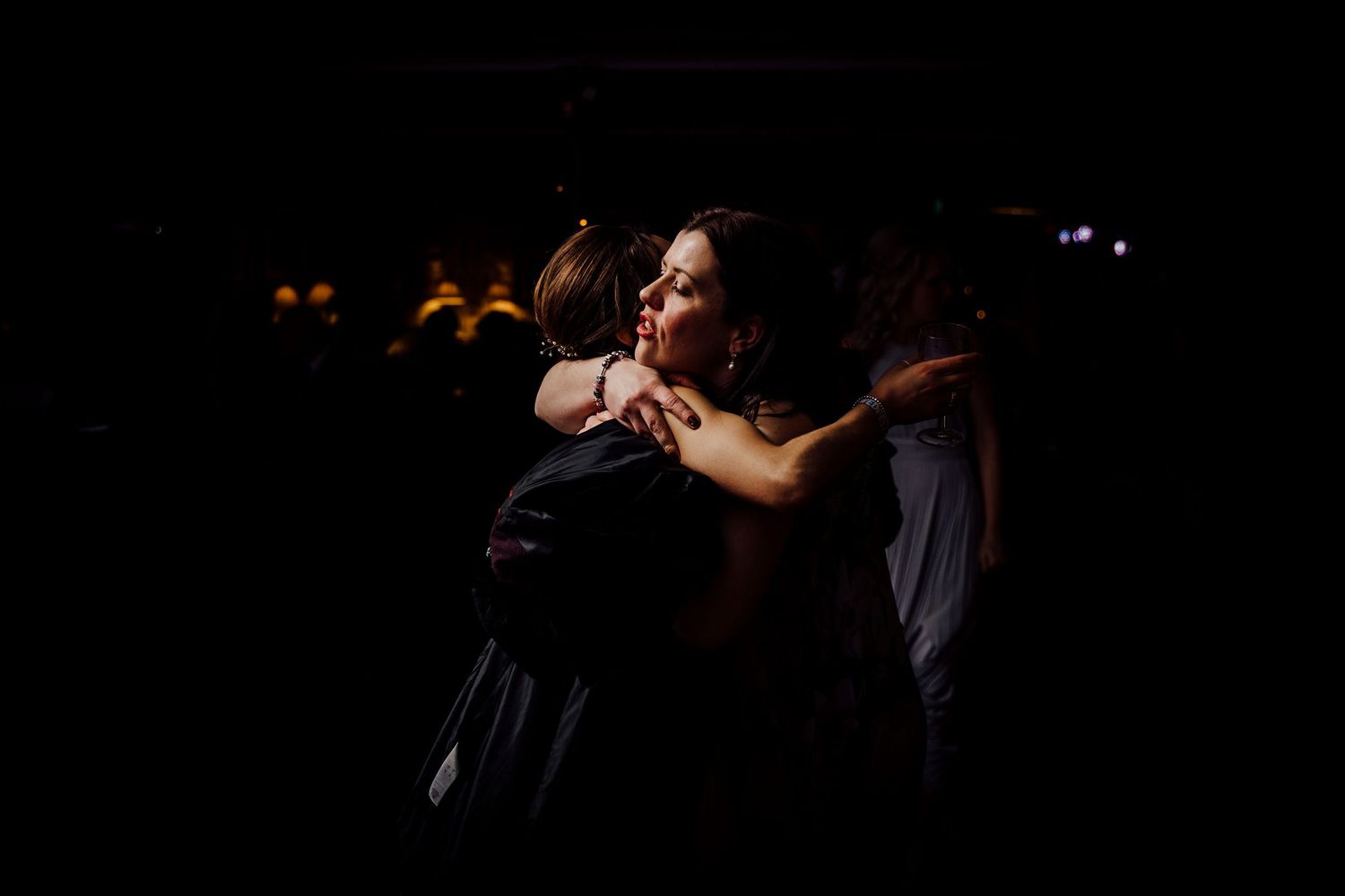 Dark and moody reception scene with dancers in silhouette.