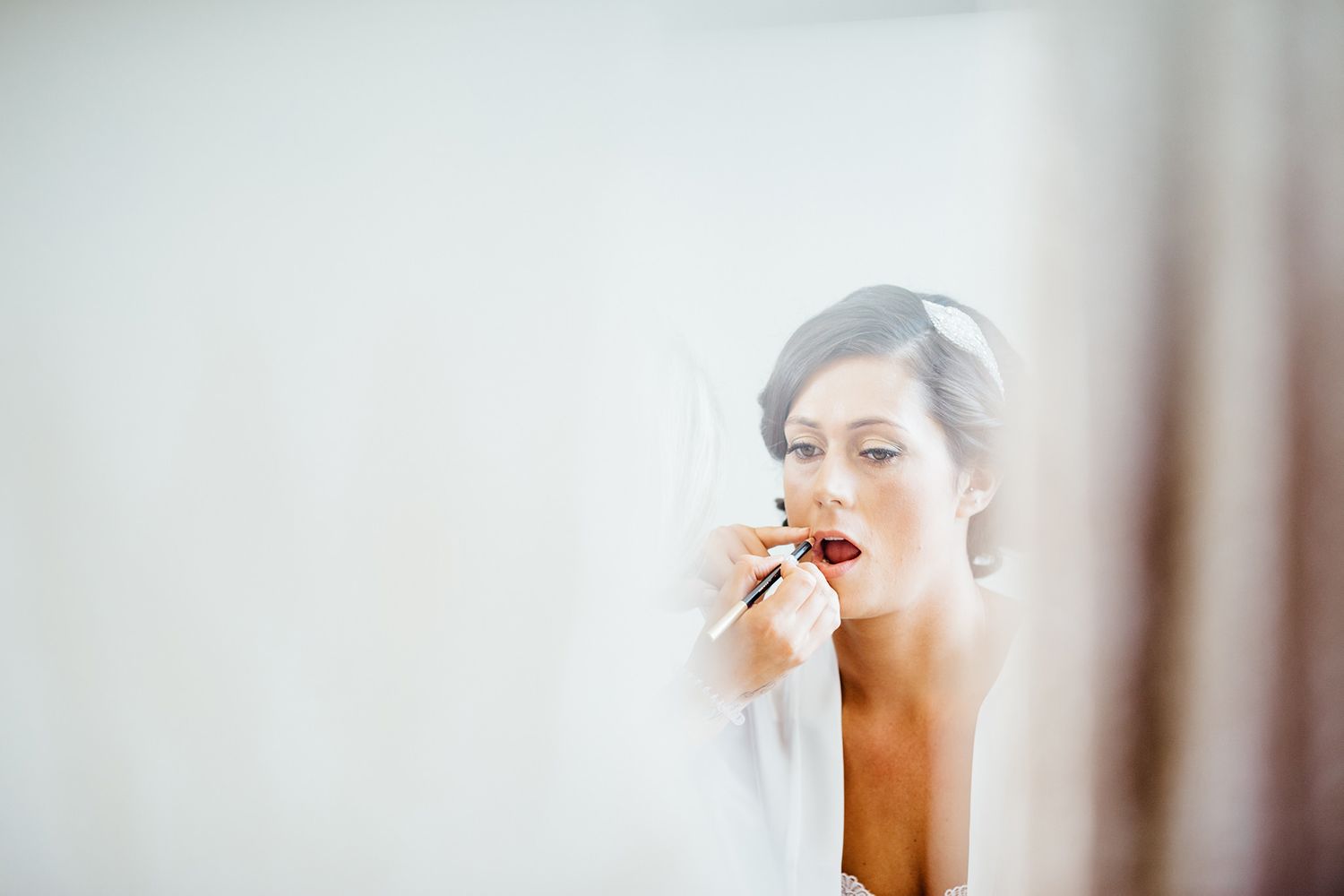 Soft focus bridal preparation moments captured in natural window light.
