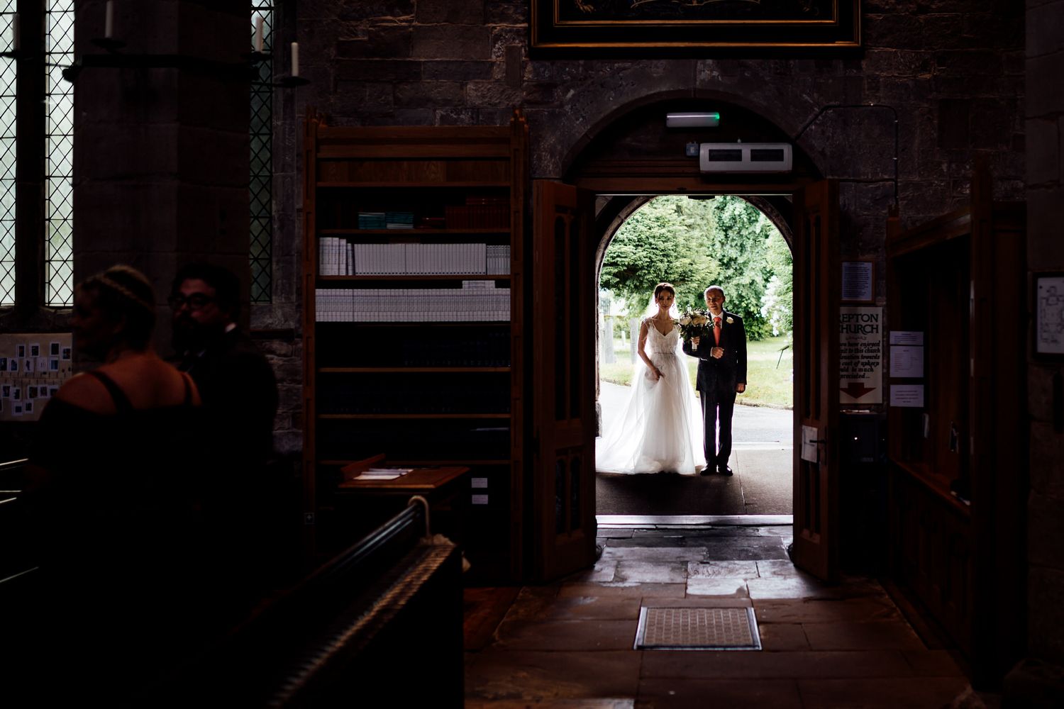 Dark wooden hallway with natural light streaming through windows creates dramatic shadows and ambiance.