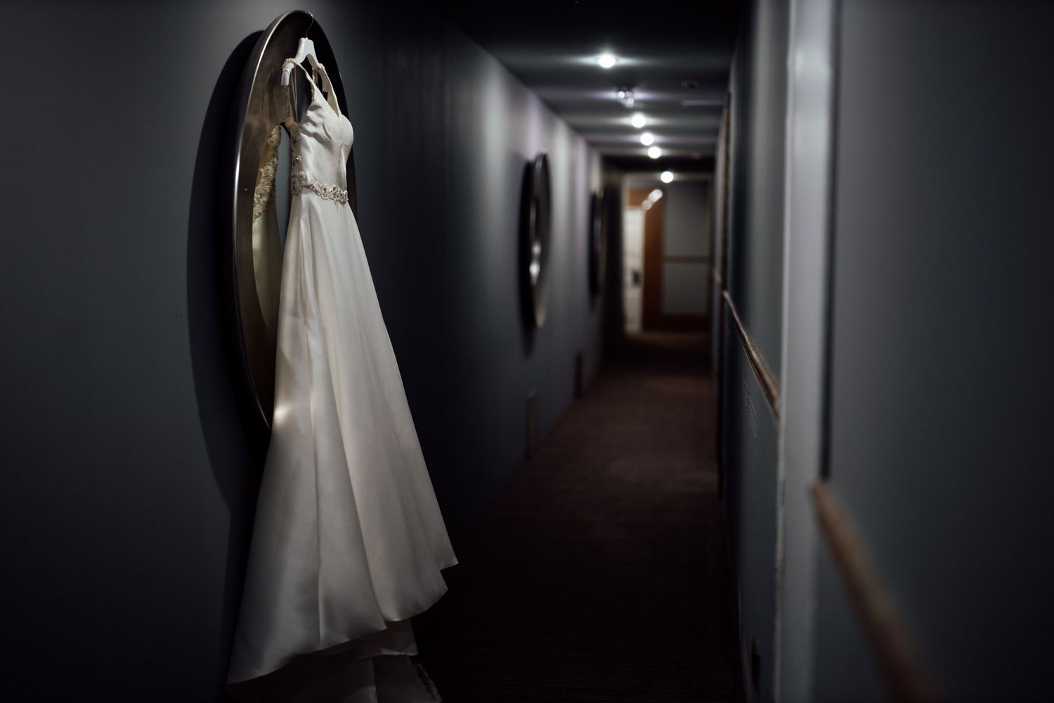 Artistic corridor shots of a bride in white dress creating dramatic shadows.