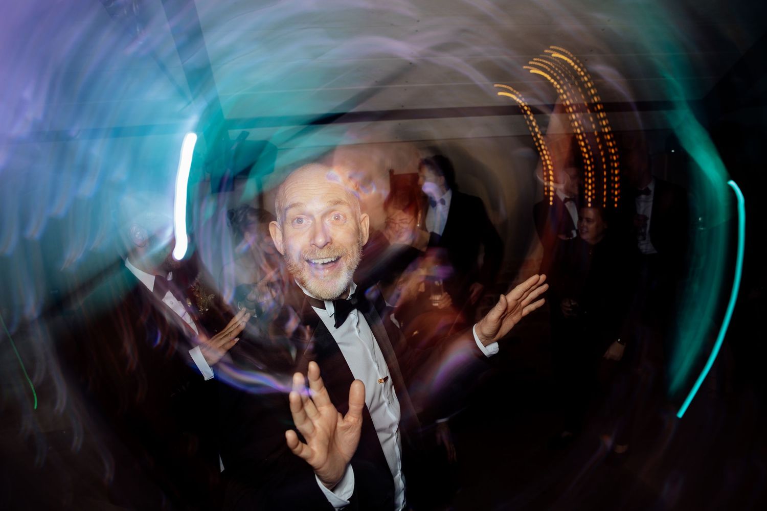 Abstract long exposure photography of wedding dance floor with swirling blue and teal light trails.