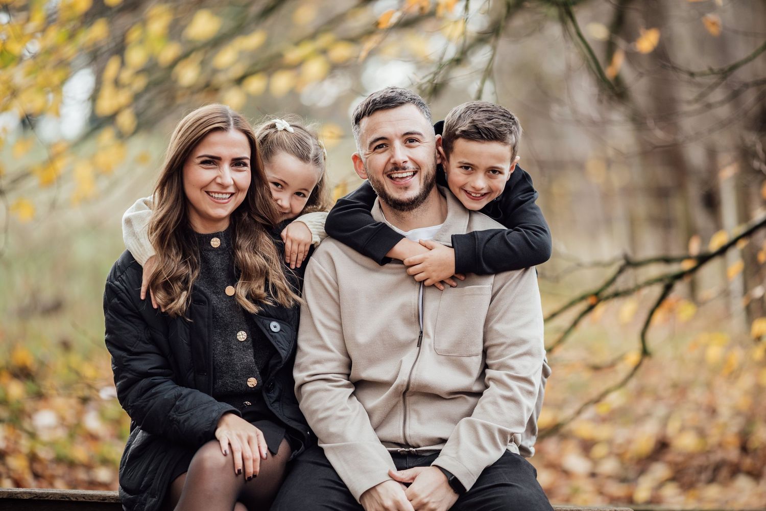 Family group sharing joyful moments together during an autumn photoshoot.