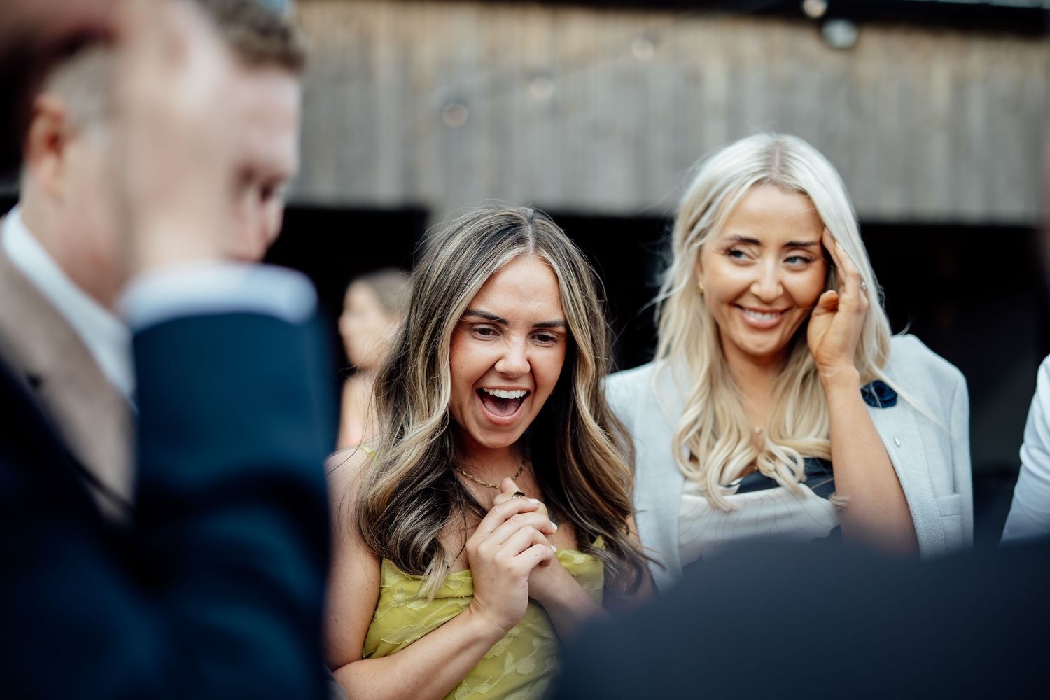 Wedding party members share laughter and candid moments during celebration.