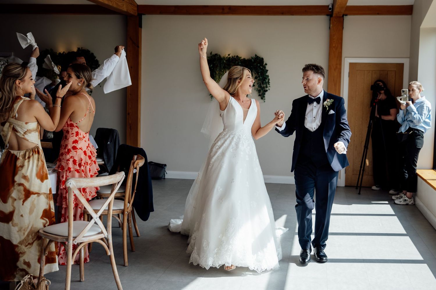 Wedding celebration inside a modern venue with wooden beam ceiling.