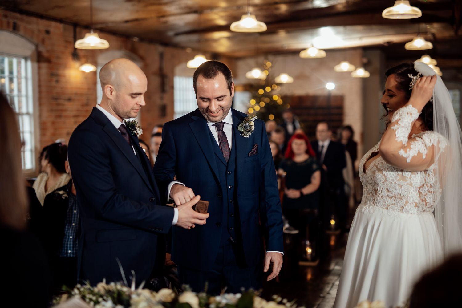 Indoor wedding celebration with vintage industrial decor and pendant lighting.