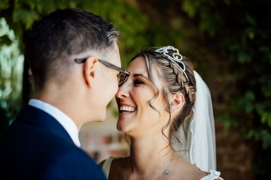 Romantic wedding portrait against natural garden backdrop.