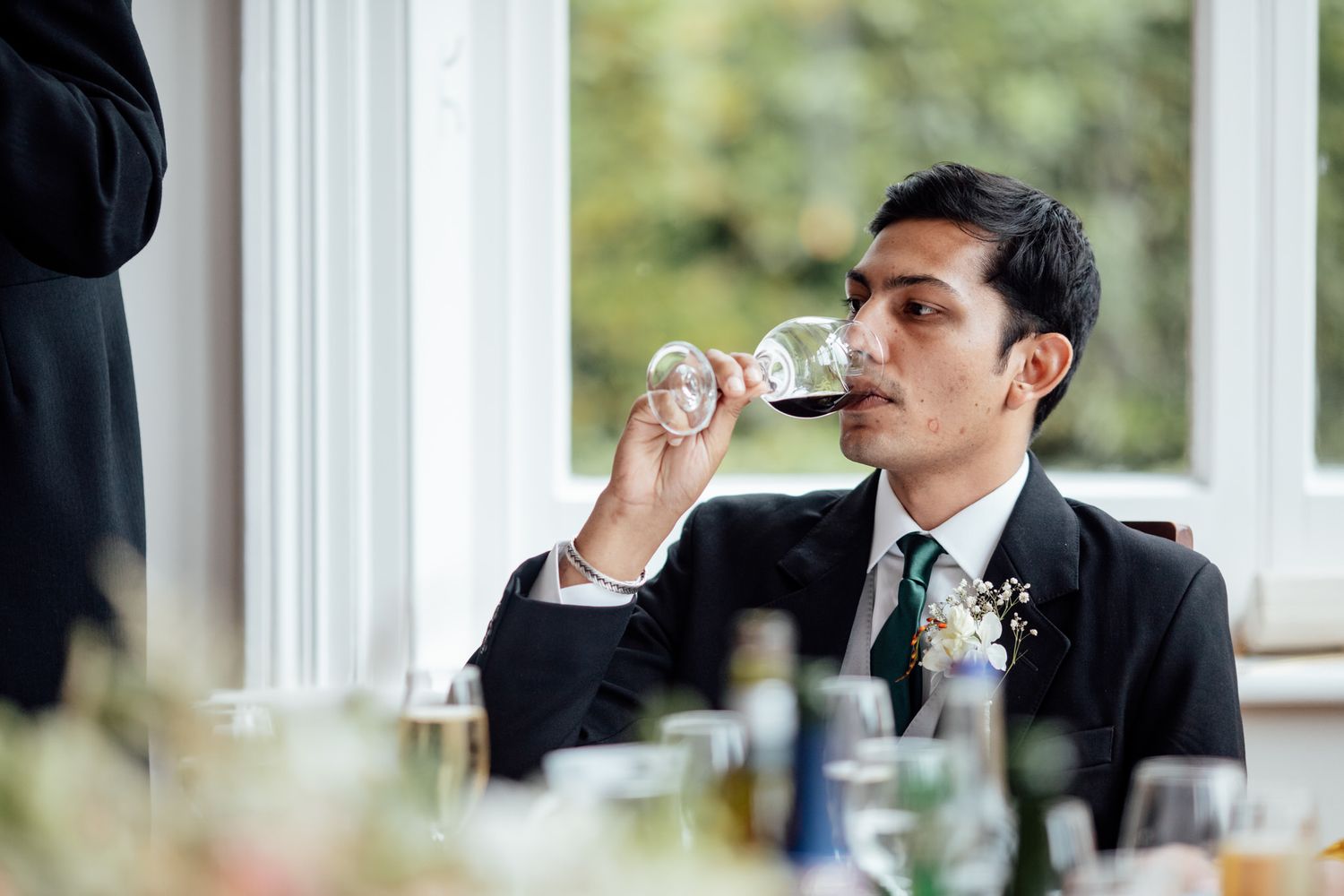 Wedding guests enjoying speeches and toasts during an indoor reception.