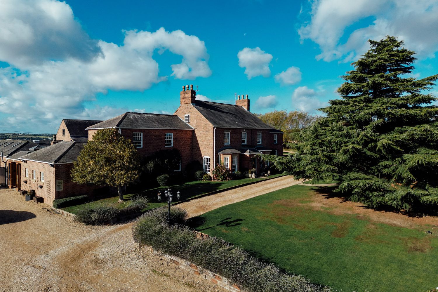 Panoramic view of countryside buildings and landscaping under blue skies.