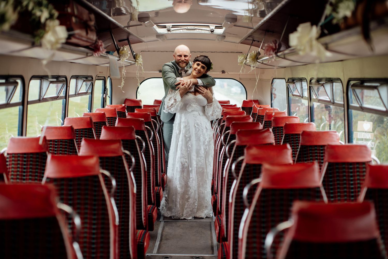 Wedding guests seated in red chairs at an outdoor ceremony venue.