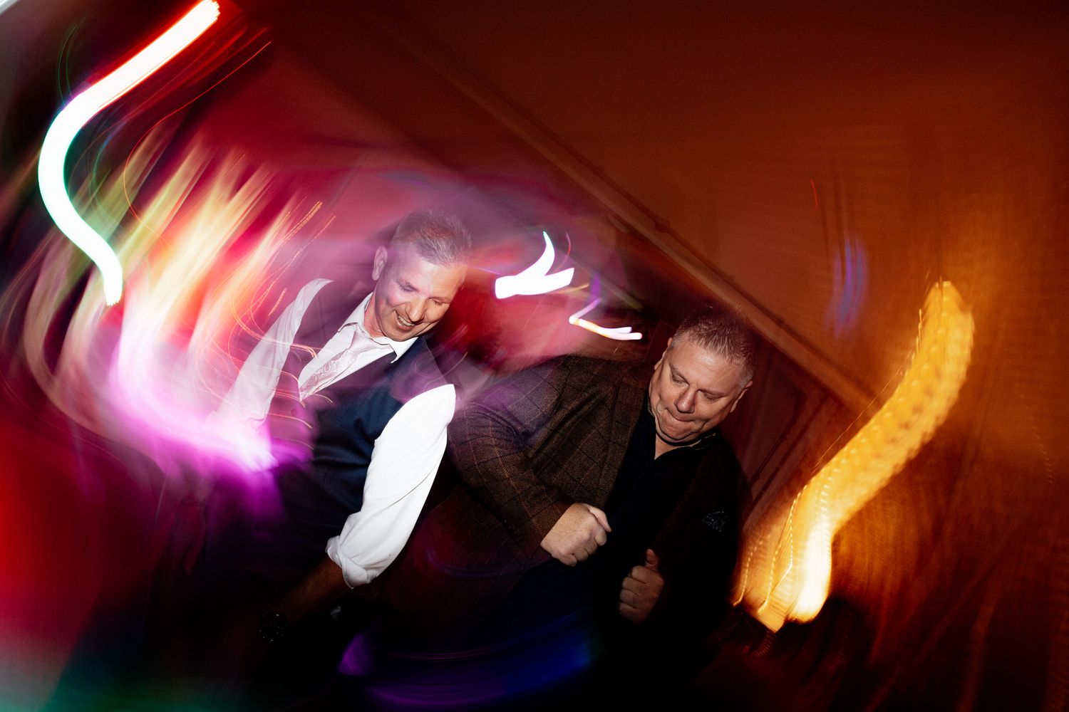 Abstract motion blur of colorful lights creating dynamic streaks in red and orange tones.