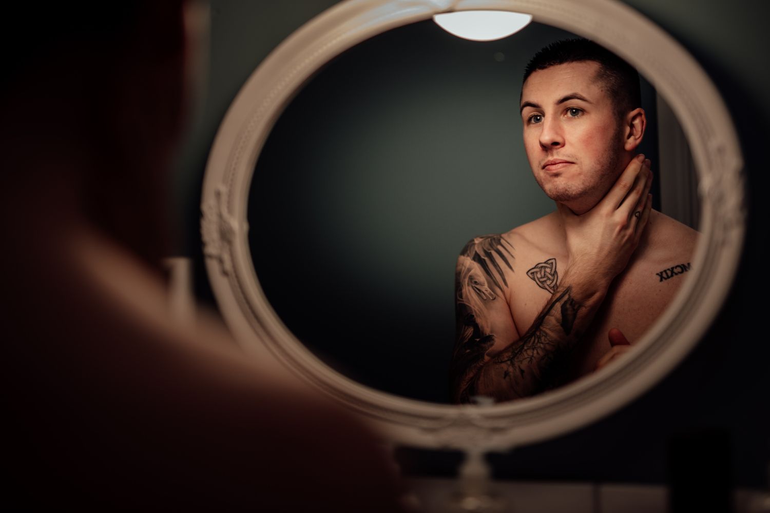 Artistic wedding portraits captured through oval vintage mirror reflections.
