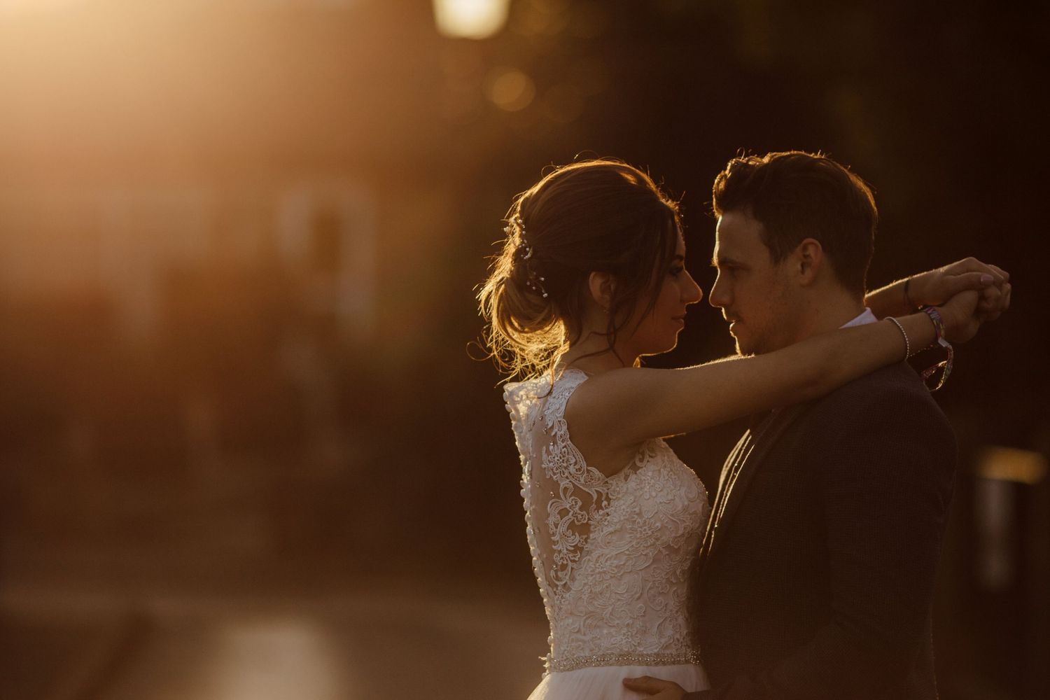 Silhouetted couple dancing during their wedding reception in warm lighting.
