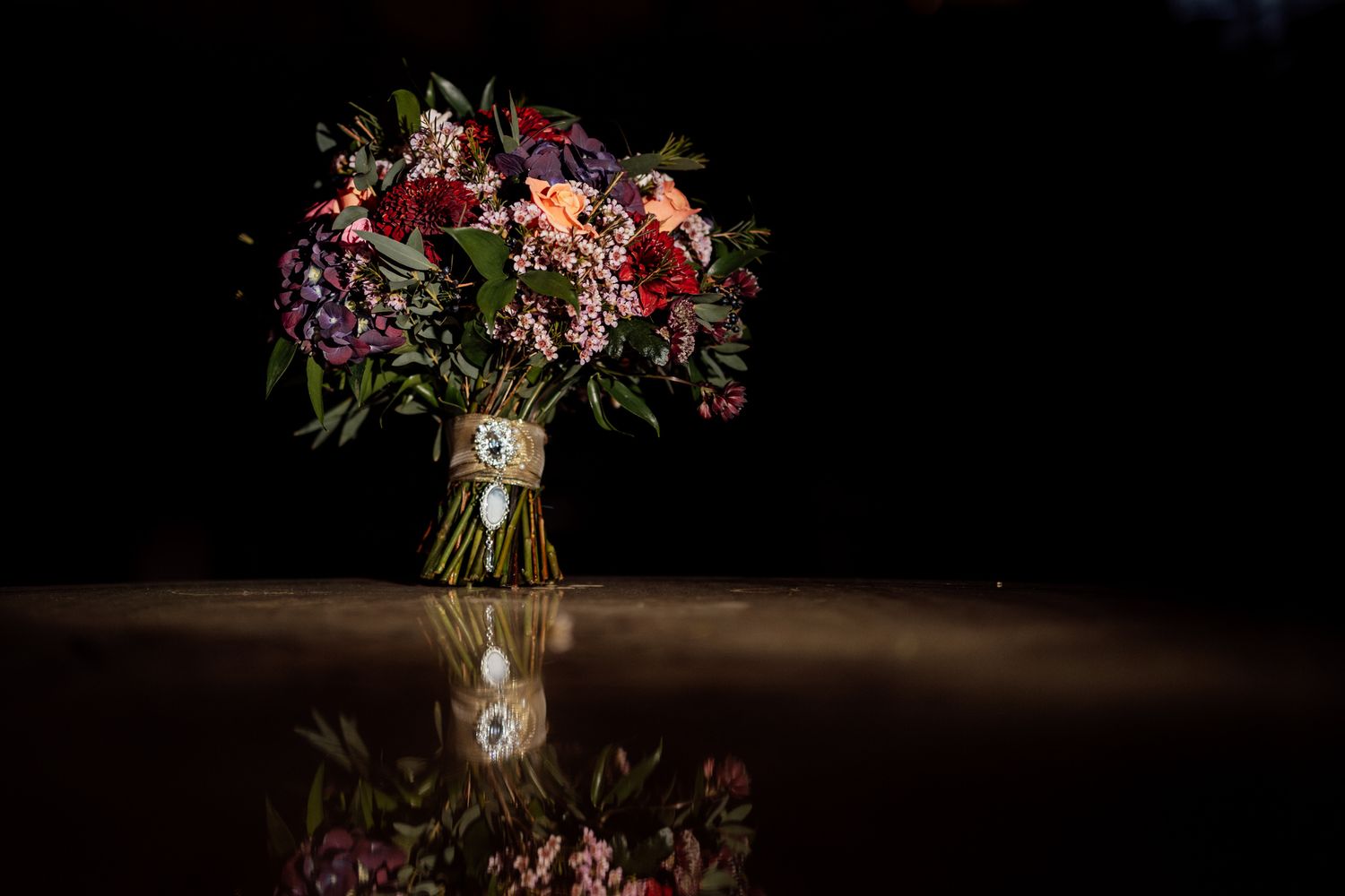 Romantic floral arrangements with deep red and pink blooms in moody lighting.