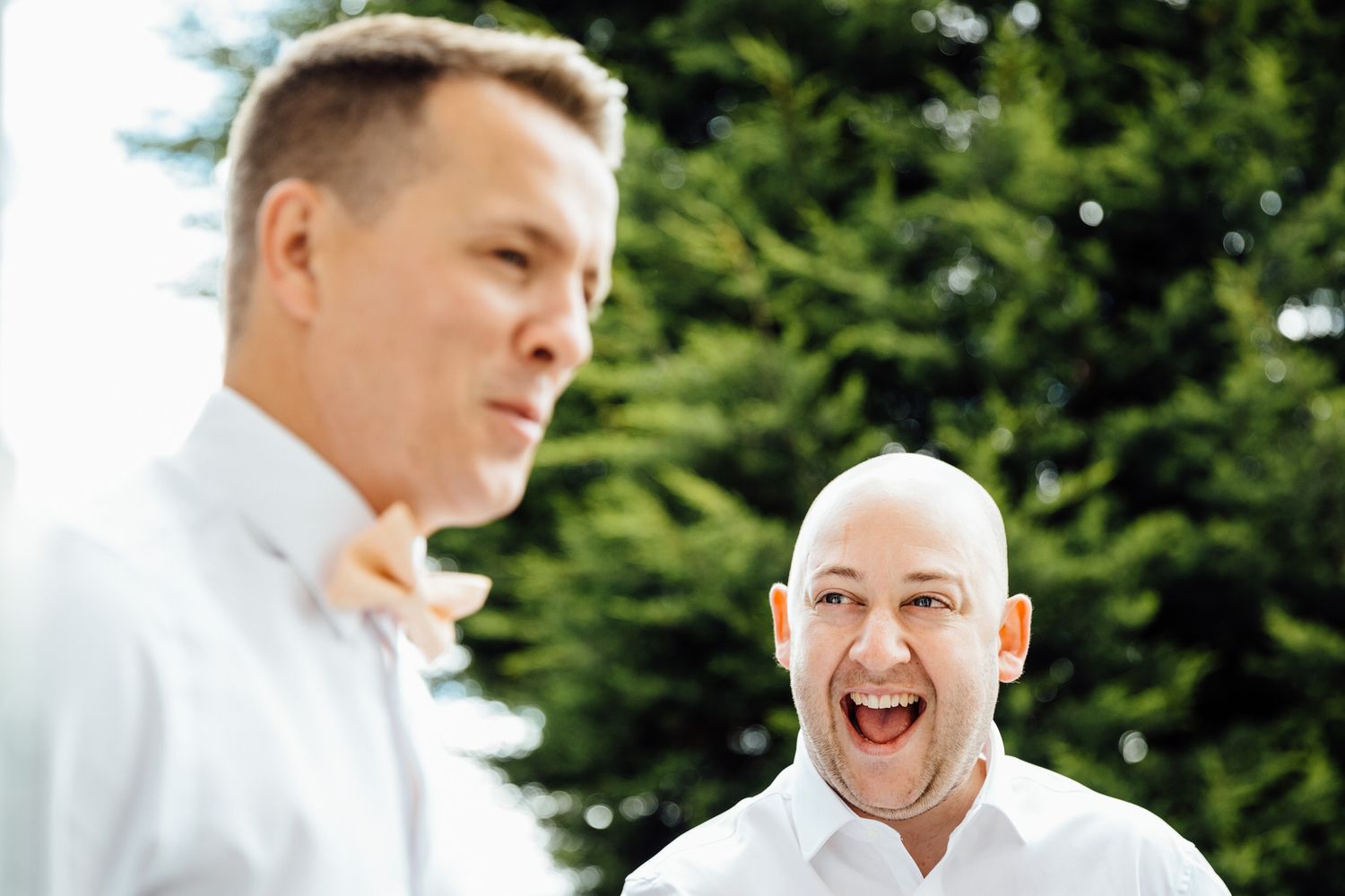 Outdoor wedding celebration in lush green garden setting.