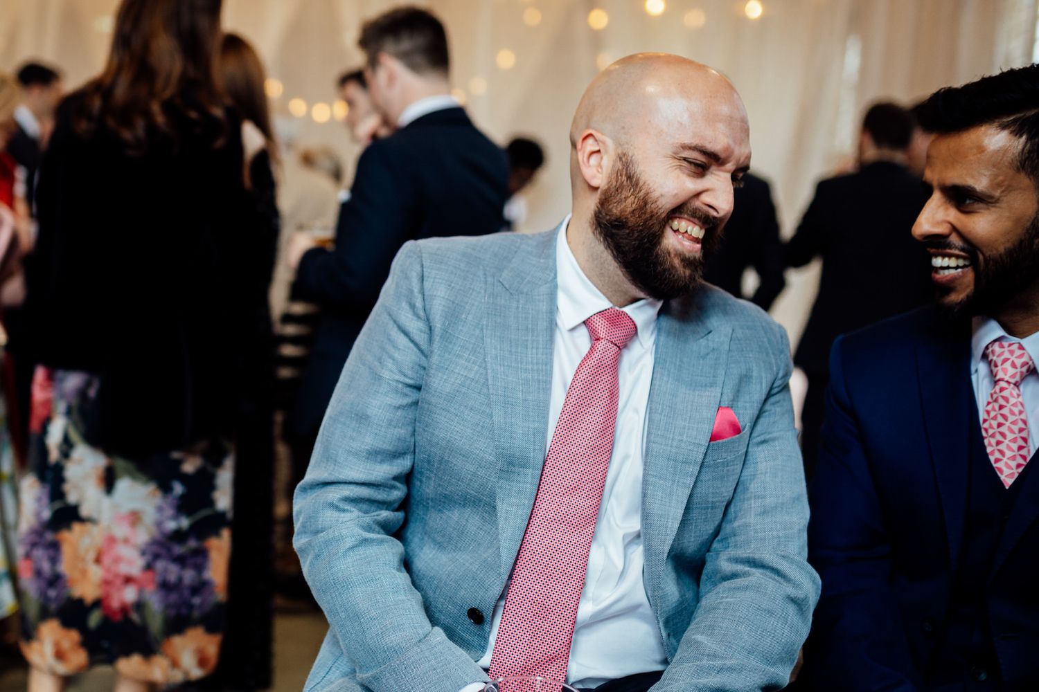 Wedding guests enjoying lively conversation at reception.