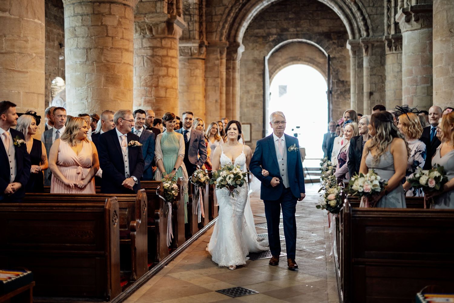 Wedding ceremony in a grand stone church with ornate architecture and natural lighting.