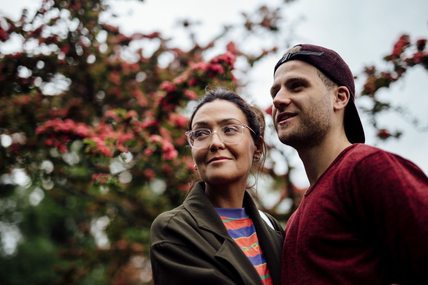 A couple shares a tender moment under autumn foliage.