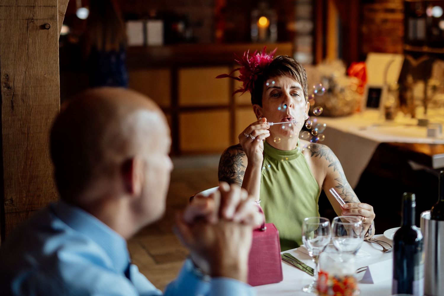 Wedding guests socializing at tables during an indoor reception celebration.