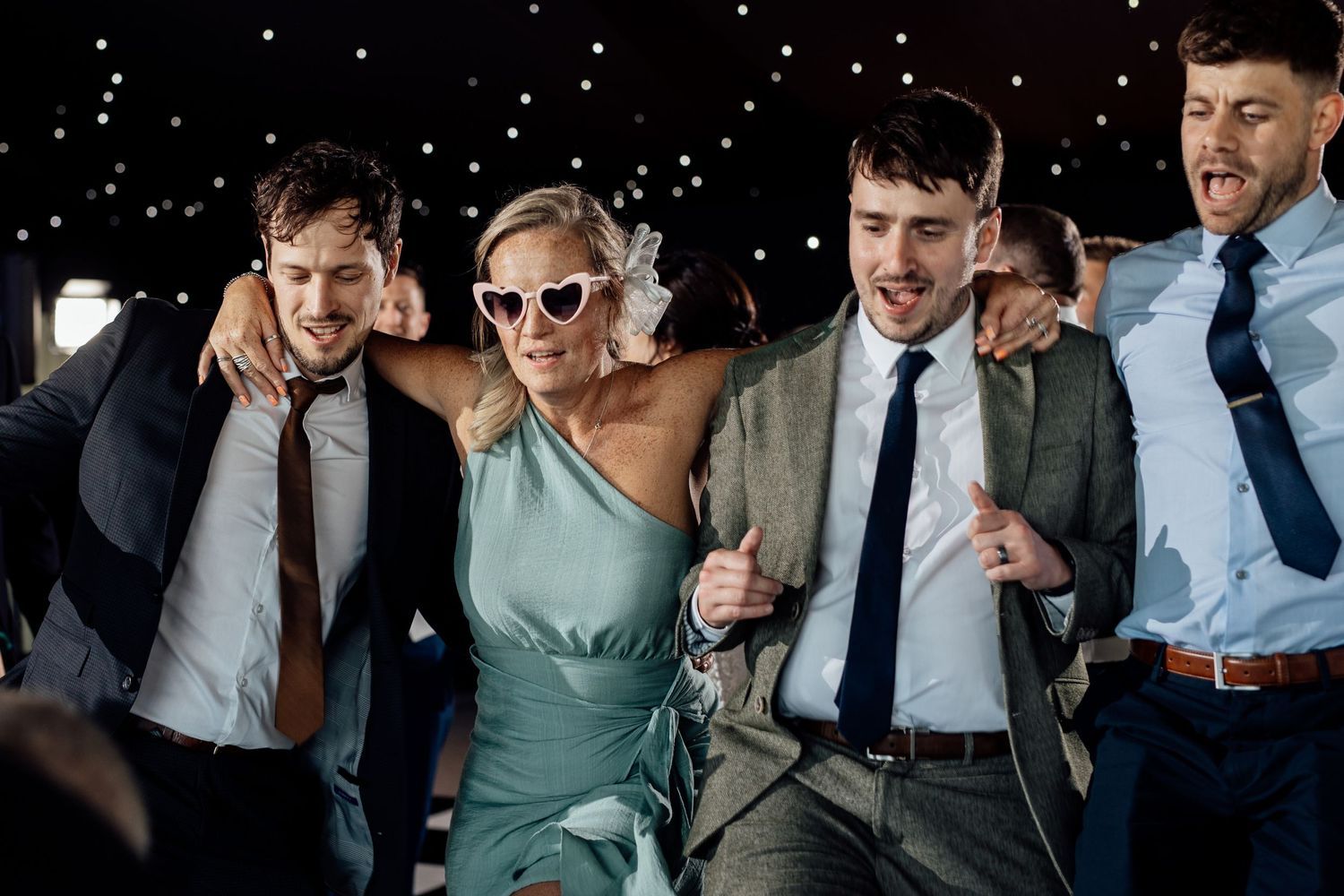 Wedding party celebrating and laughing together during a festive reception.