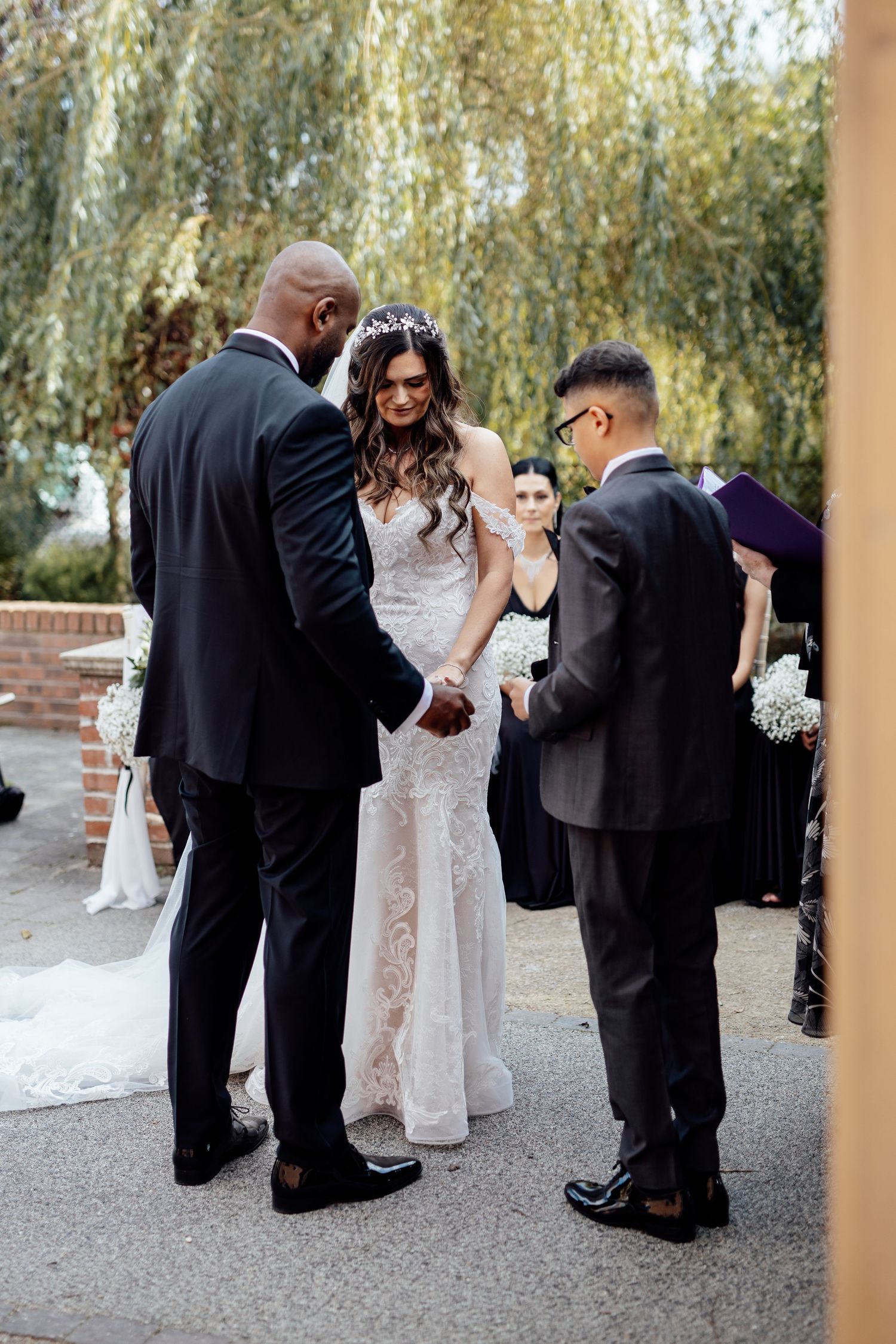 Wedding party gathered outdoors for formal photos under natural lighting.