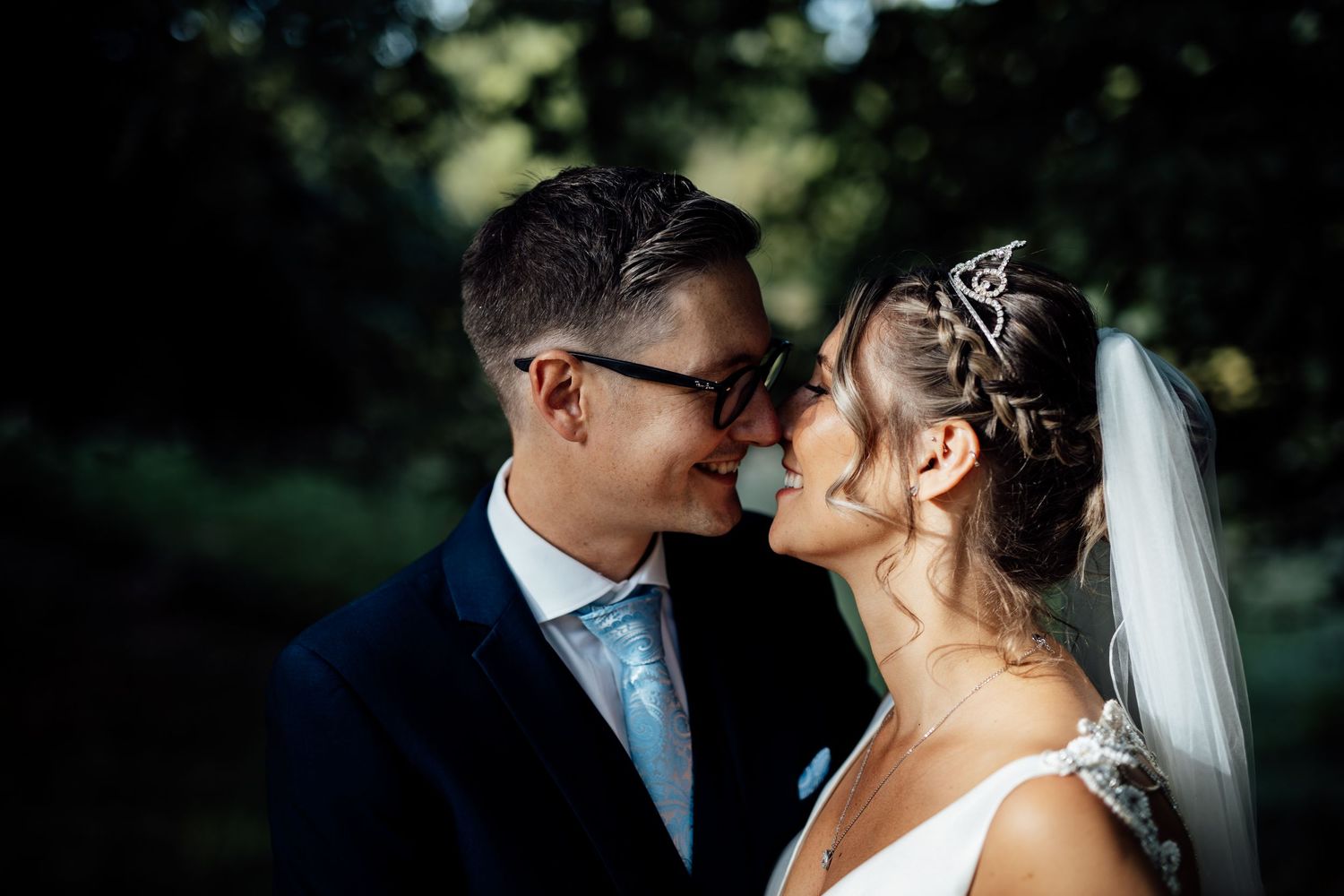 Romantic outdoor wedding ceremony with white floral arrangements and guests seated in rows.