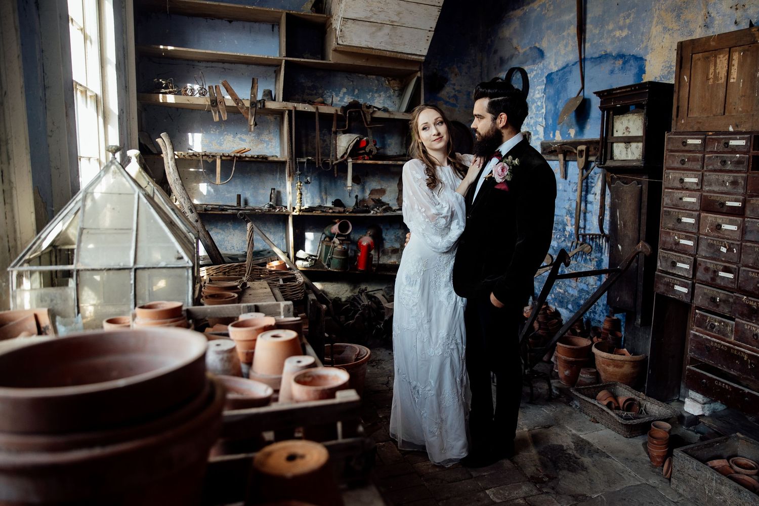 Vintage industrial interior with antique furniture and moody lighting creates atmospheric wedding scene.