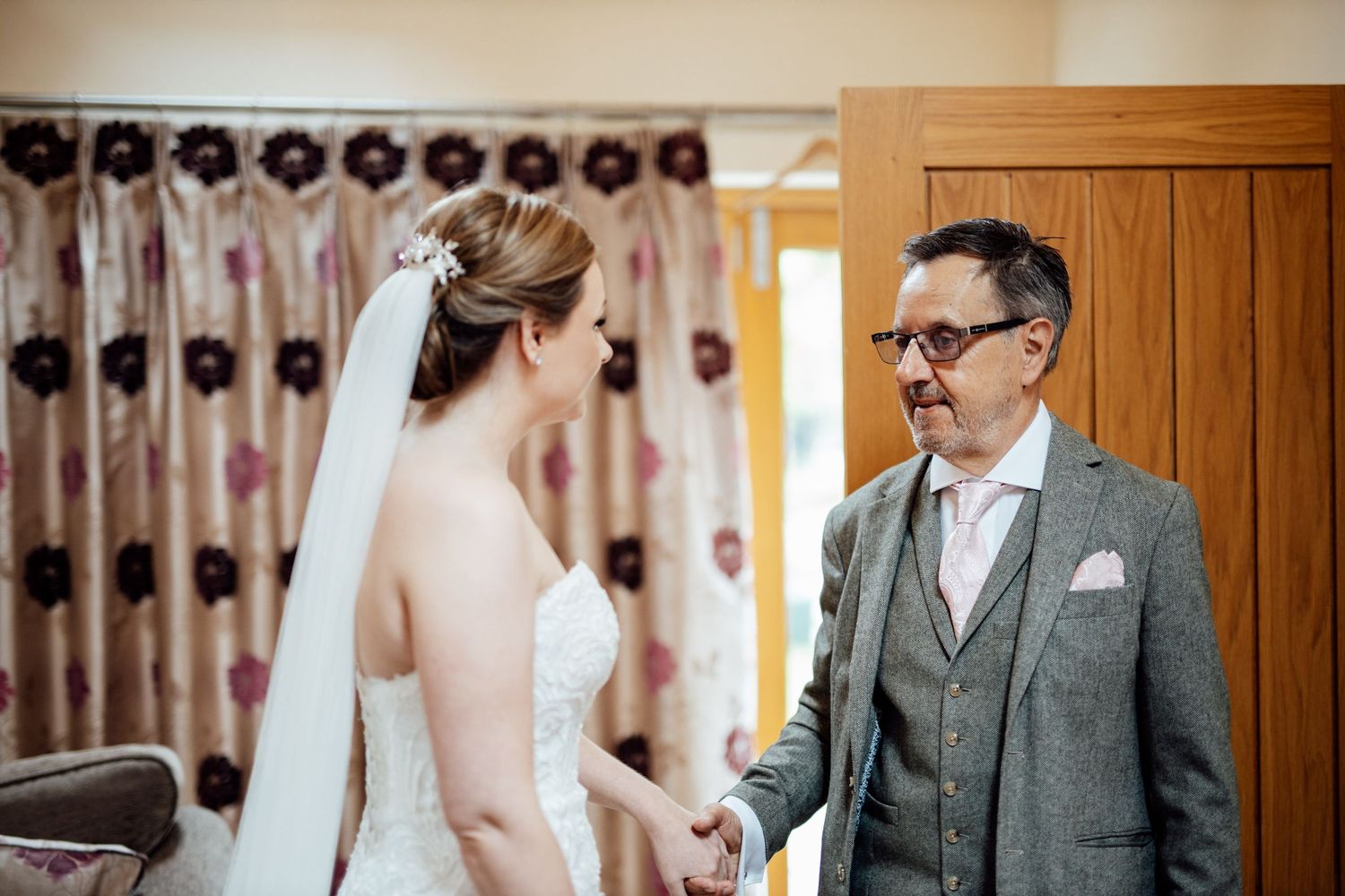 Wedding venue interior with elegant curtains and wooden paneling in warm lighting.