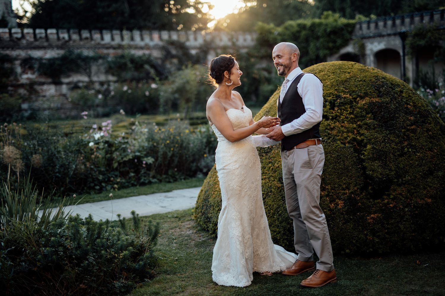 Sunset wedding portraits in a lush garden setting with golden hour lighting.