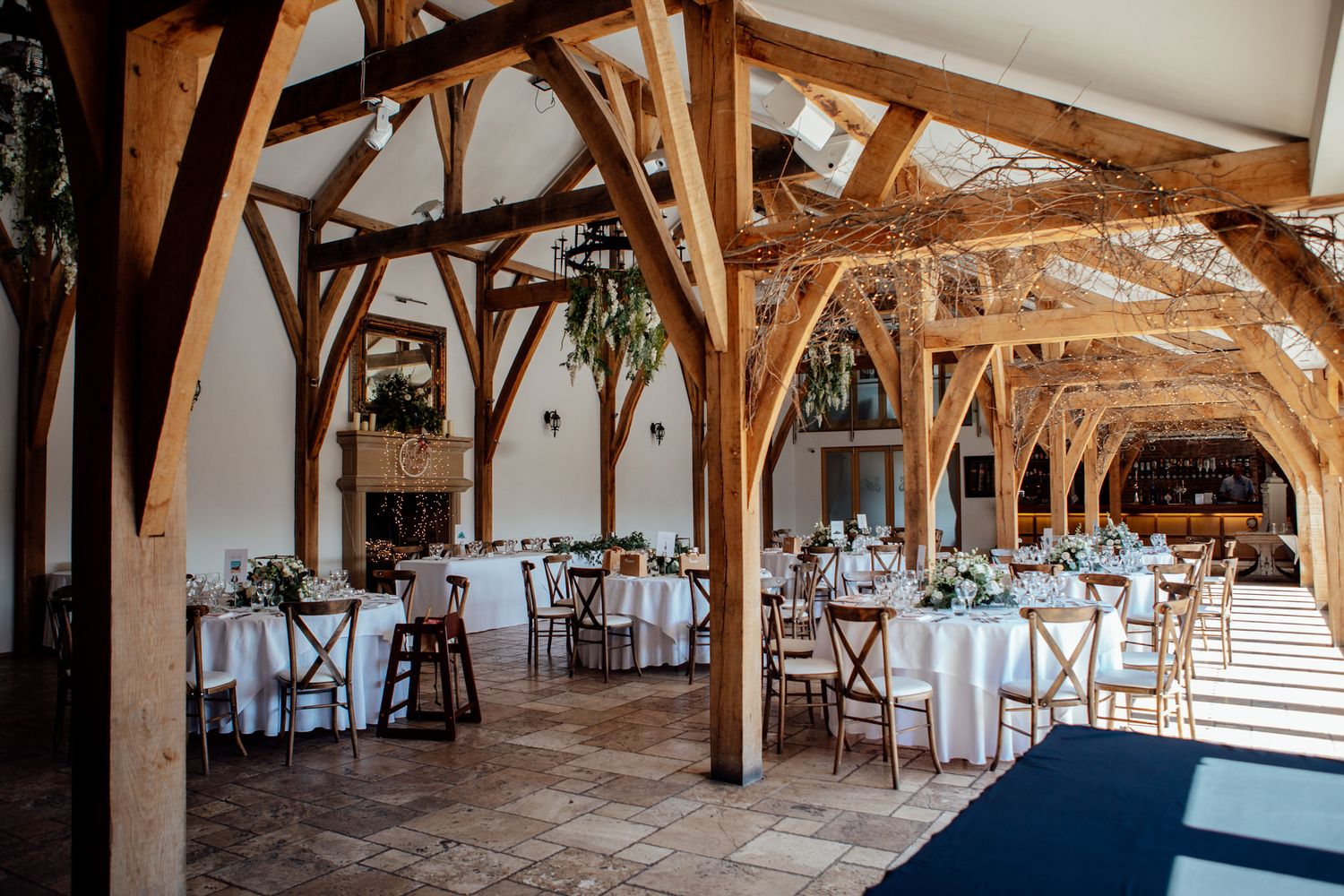 Rustic barn wedding reception setup with wooden beams and elegant table settings.