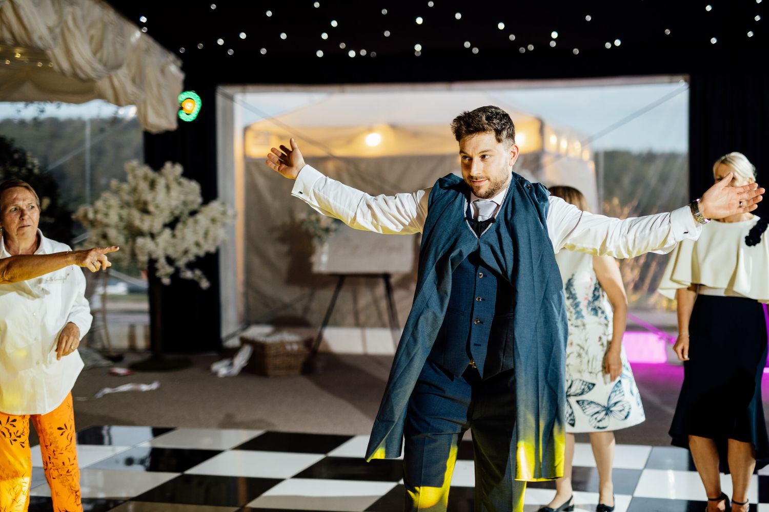 Wedding reception dance floor filled with joyful celebration under twinkling lights.