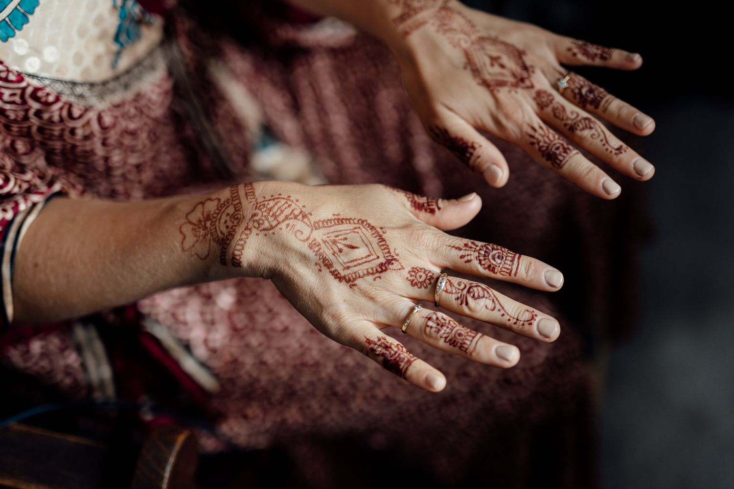 Close-up details of intricate henna designs on hands.