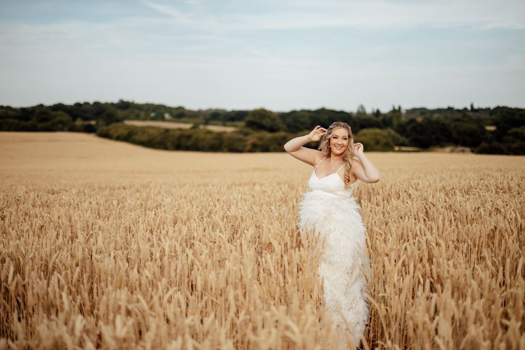 Romantic couple portraits in golden wheat field during summer wedding.