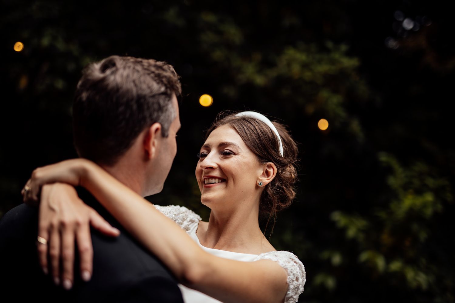 Wedding guests dancing and celebrating at an indoor reception venue.
