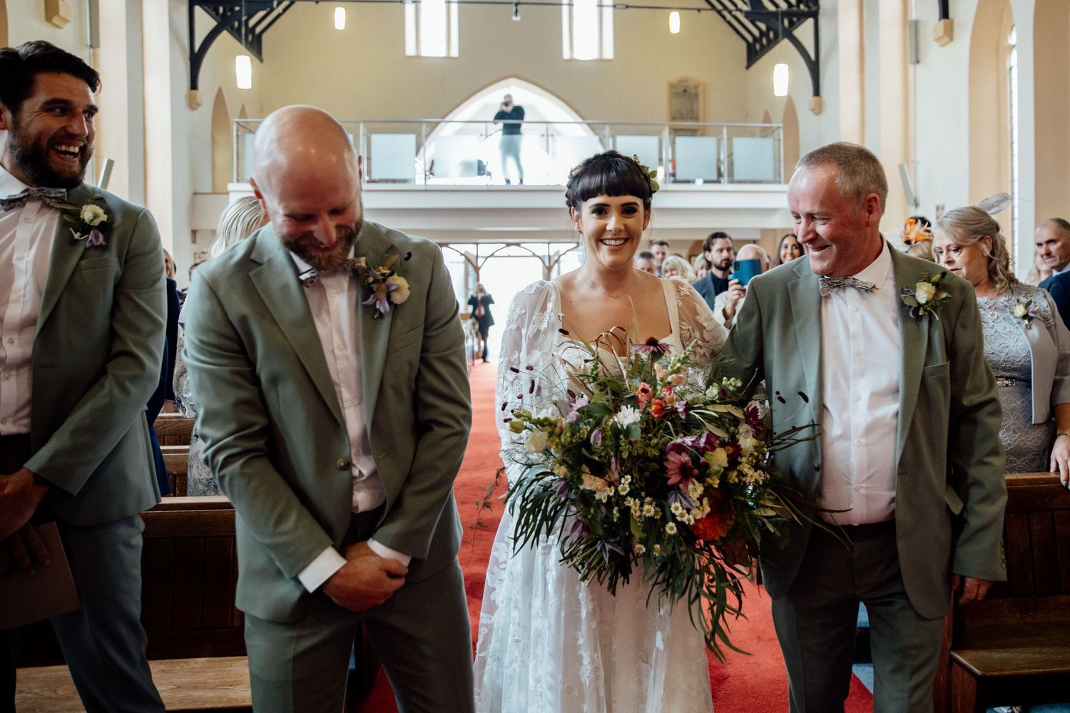 Wedding ceremony in a traditional church with high ceilings and elegant architectural details.