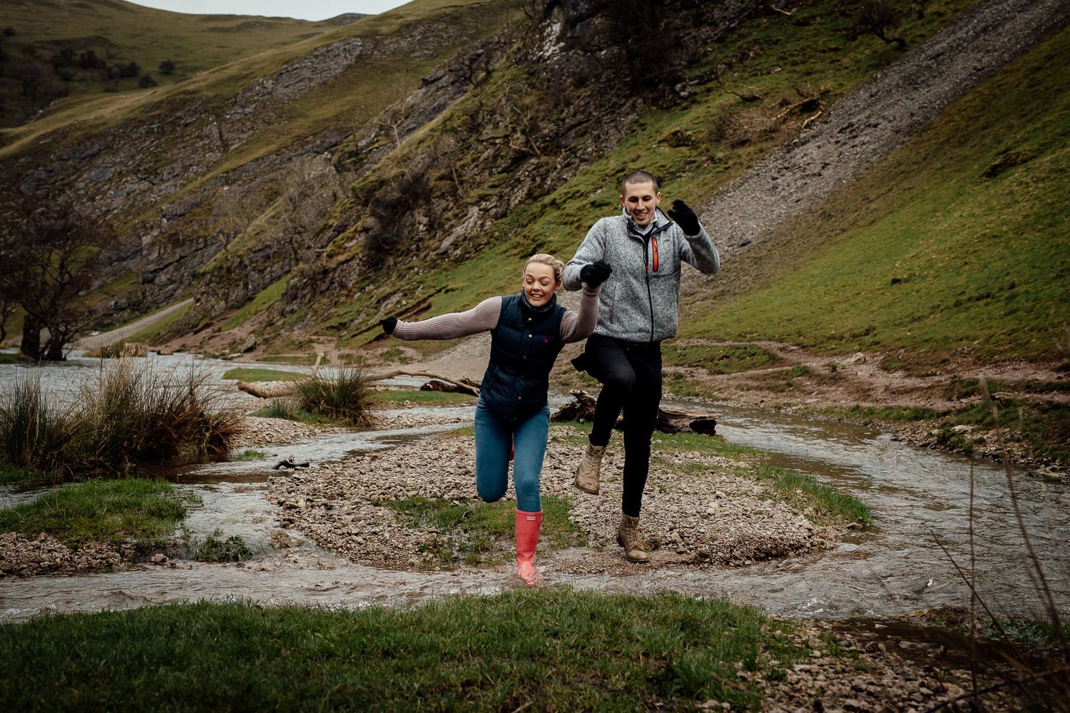 Hikers exploring a rocky mountain trail with scenic valley views.