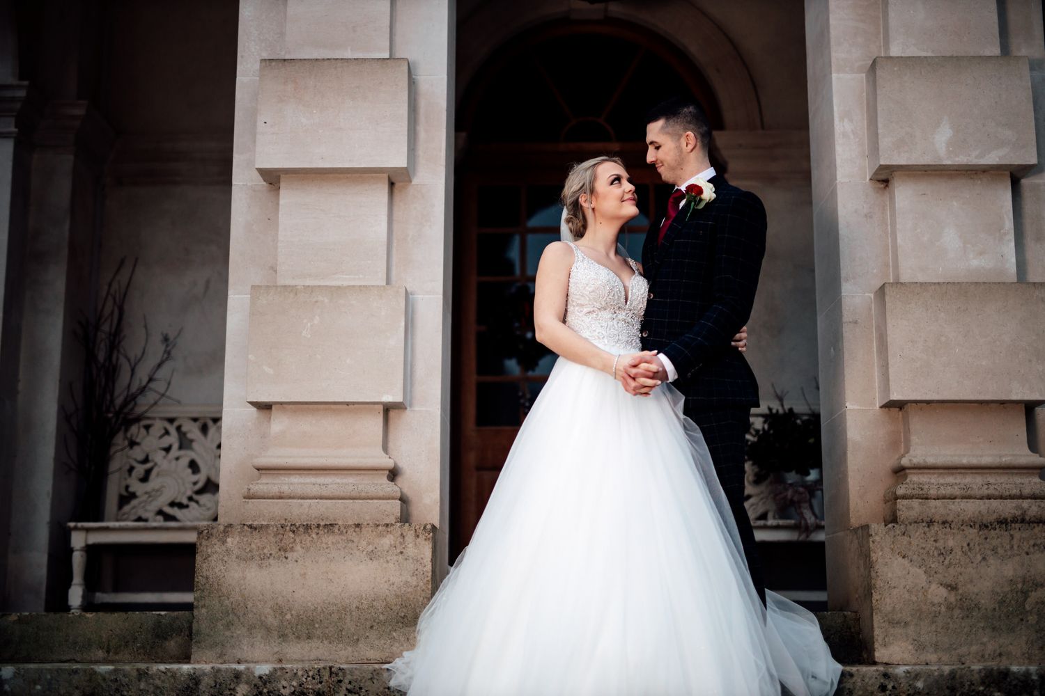 A joyful wedding moment captured under classic stone architecture.