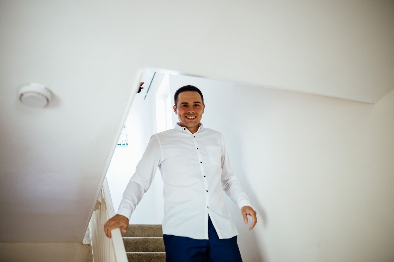 Wedding preparations in a bright, minimalist room with white decor.