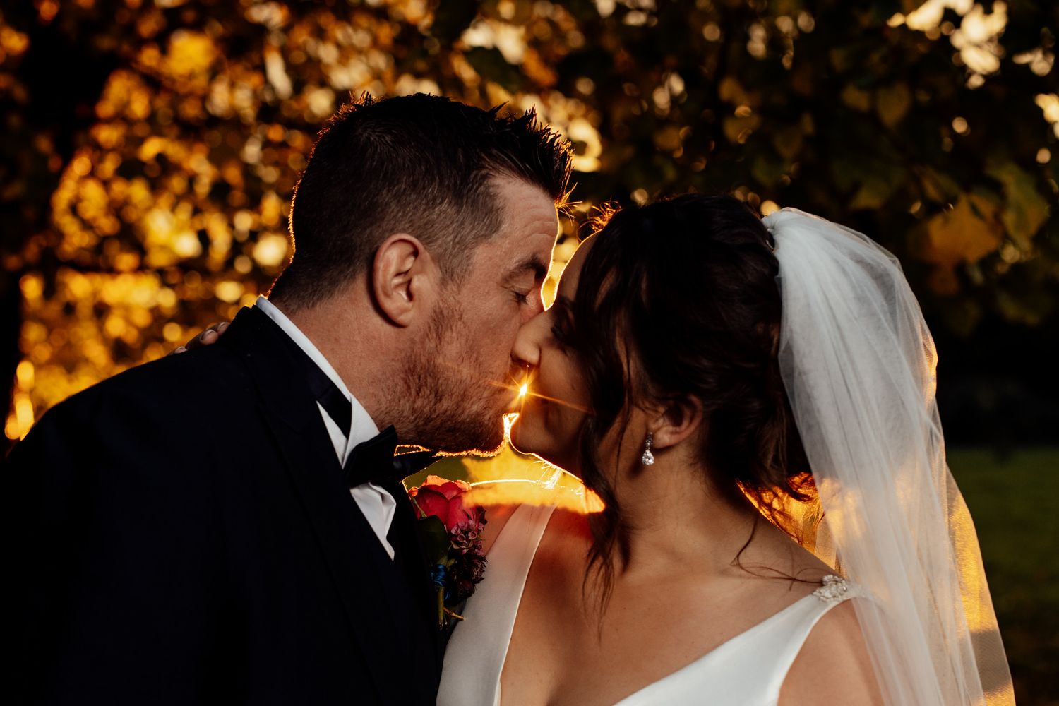 Romantic sunset wedding portraits with glowing bokeh lights in the background.