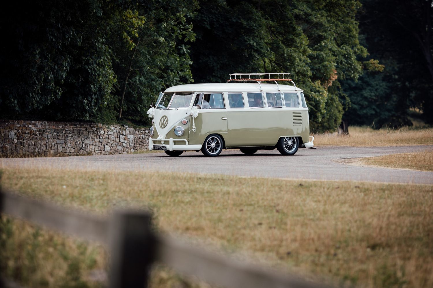 Classic white vintage Volkswagen van parked on a grassy field.