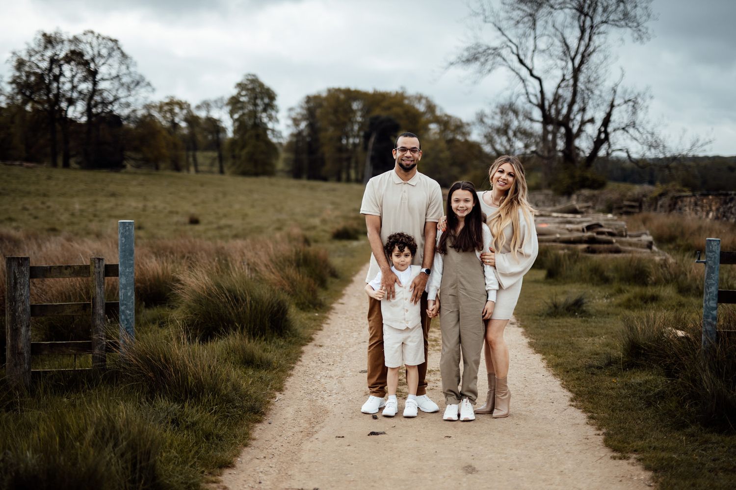 Family walking together on a winding dirt path through a natural landscape.