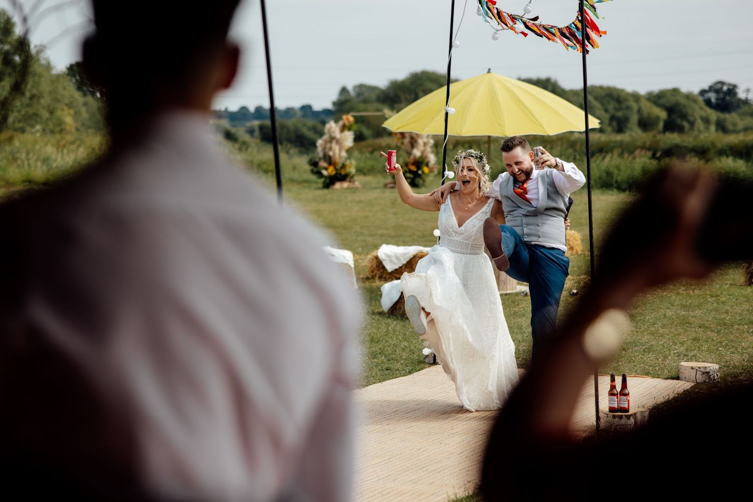 Outdoor wedding celebration with decorative elements and a yellow umbrella.